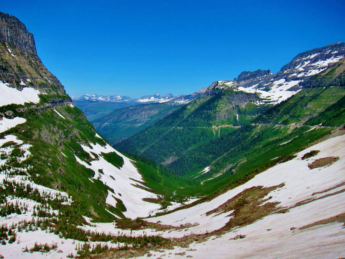 A view of the Going To The Sun Road that takes you across the Rockeis in the most beautiful mountain pass in America! Glacier National Park Itinerary: A complete and illustrated day-by-day itinerary for visiting the most beautiful national park in the US!
