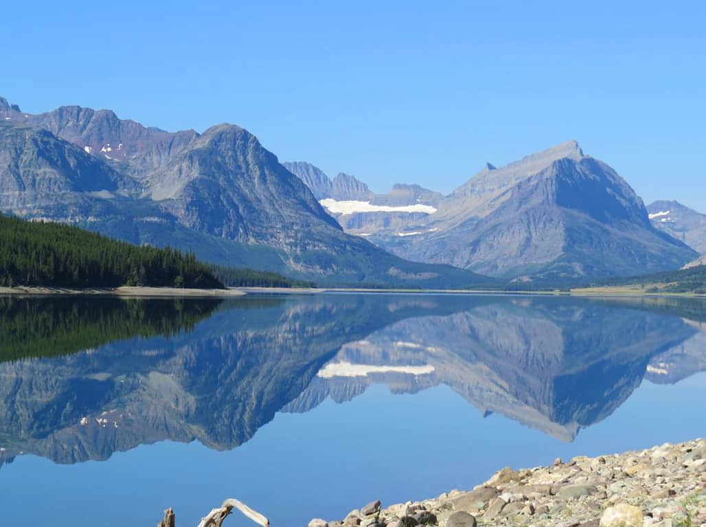 Reflections on Lake Sherburne. Glacier National Park Itinerary: A complete and illustrated day-by-day itinerary for visiting the most beautiful national park in the US!