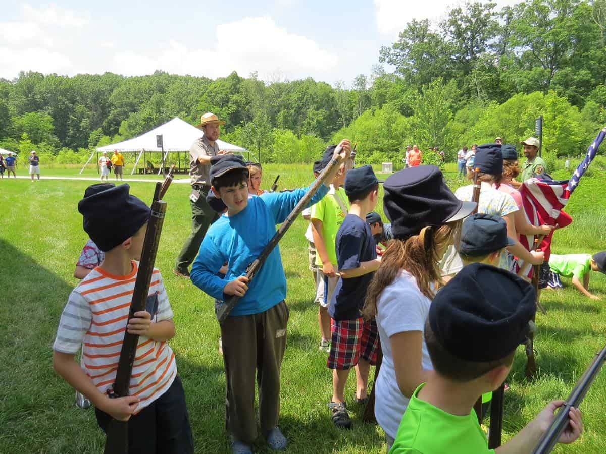 Kids holding toy guns with the instructor behind them at a Jr. Ranger activity at Gettysburg