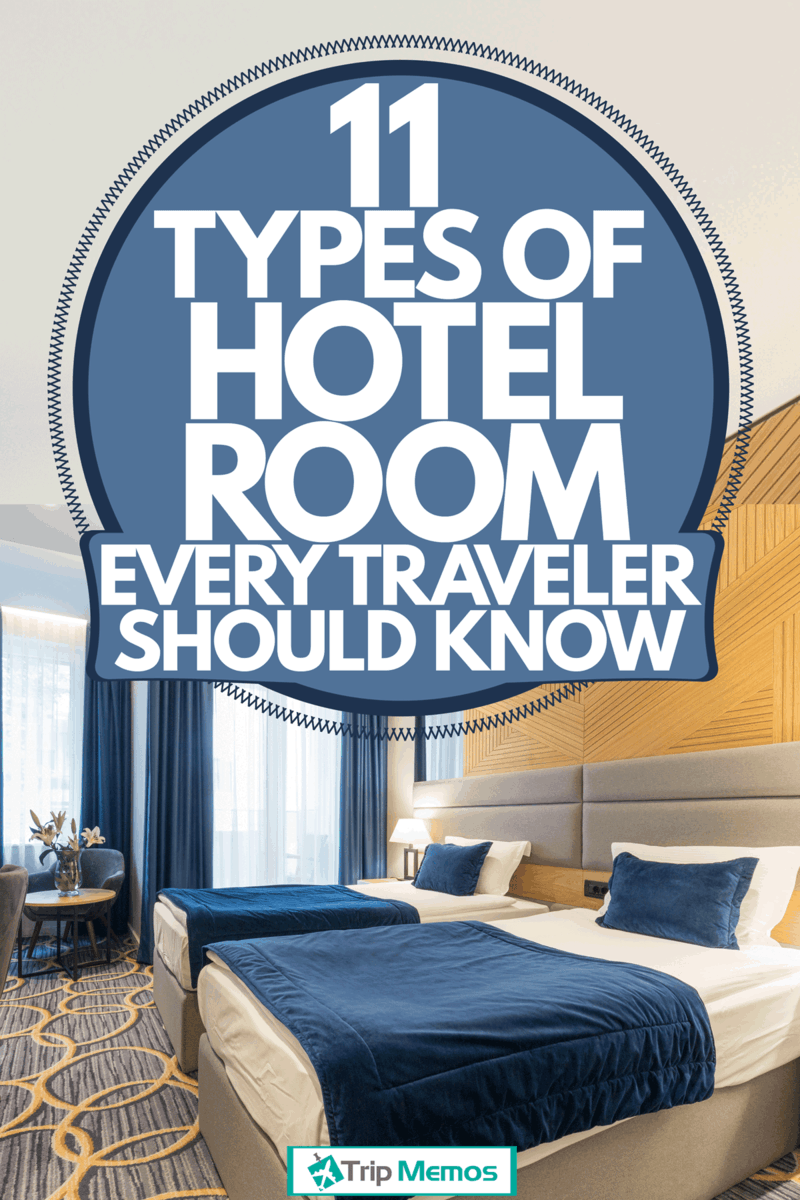 A twin bedroom hotel room with blue beddings, blue curtains, and a header wall made with wood, 11 Types of Hotel Rooms Every Traveler Should Know