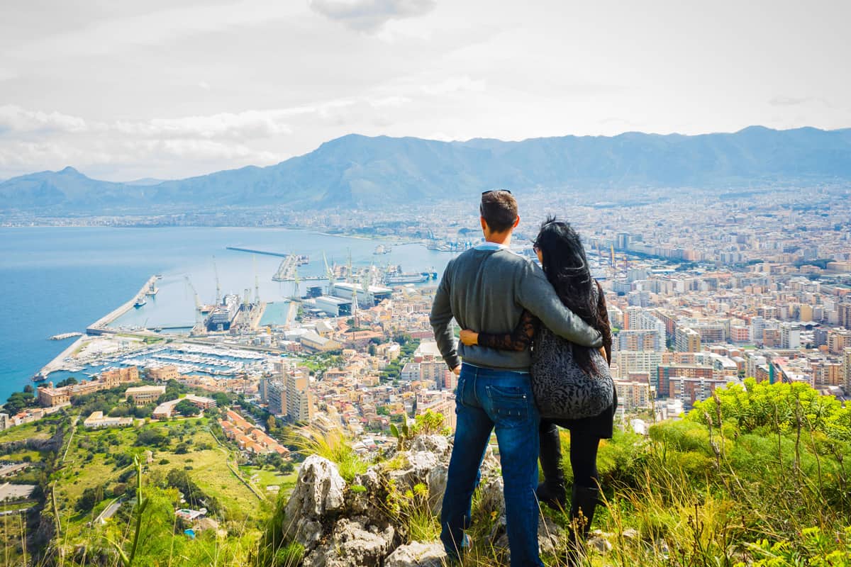 A couple watching and enjoying view above city of Palermo on top of Mount Pellegrino, Palermo, Sicily, Italy