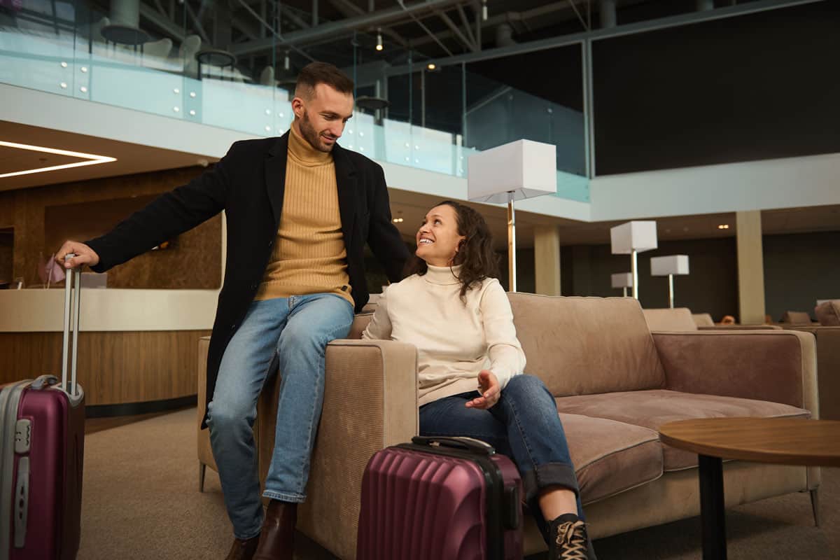 A couple sitting at the airport lounge getting ready for their flight