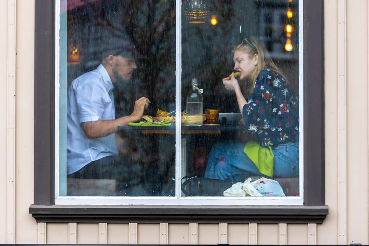 a couple is siting in the window enjoying a delicious lunch while spending quality time together