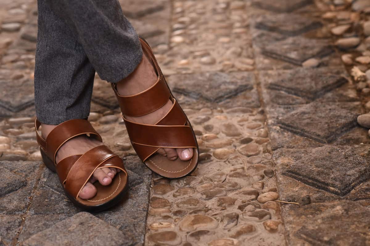 Close up of men foot wearing genuine Sandal leather shoes or vintage leather sandal shoe on kurta shalwar suit.