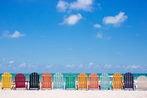 Different colors of chairs laid out on the beach line, Uncovering Florida's Unique Outdoor Adventures