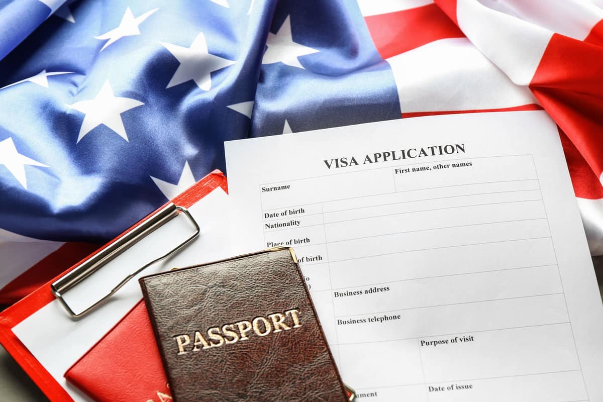 Passport, American flag and visa application form on table