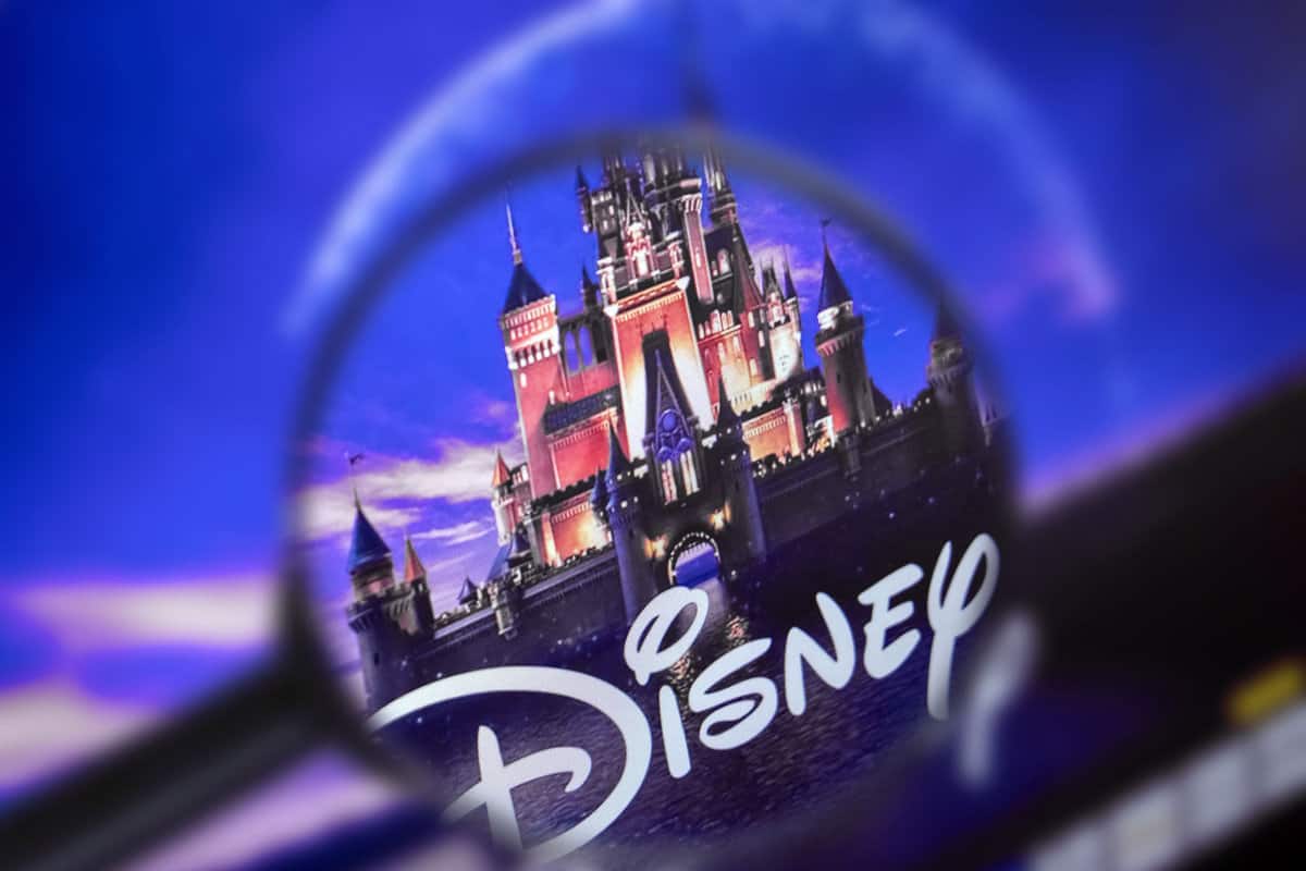 The home page of the Disney site, view through a magnifying glass. Disney company logo is visible. Soft focus.