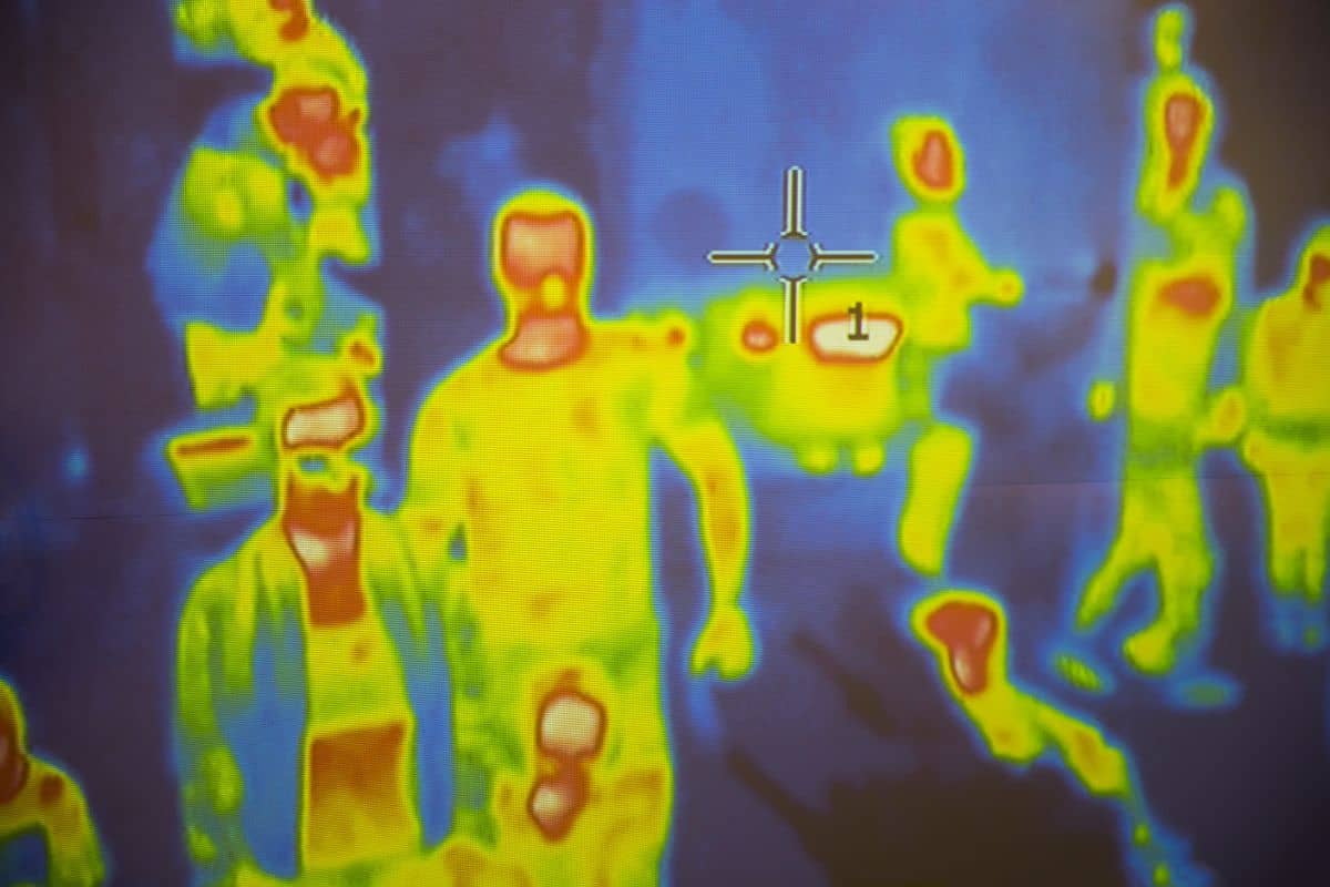 Thermal scanner / camera detecting infected people with Covid-19. Group of people under thermal imaging camera. Modern airport checking system.