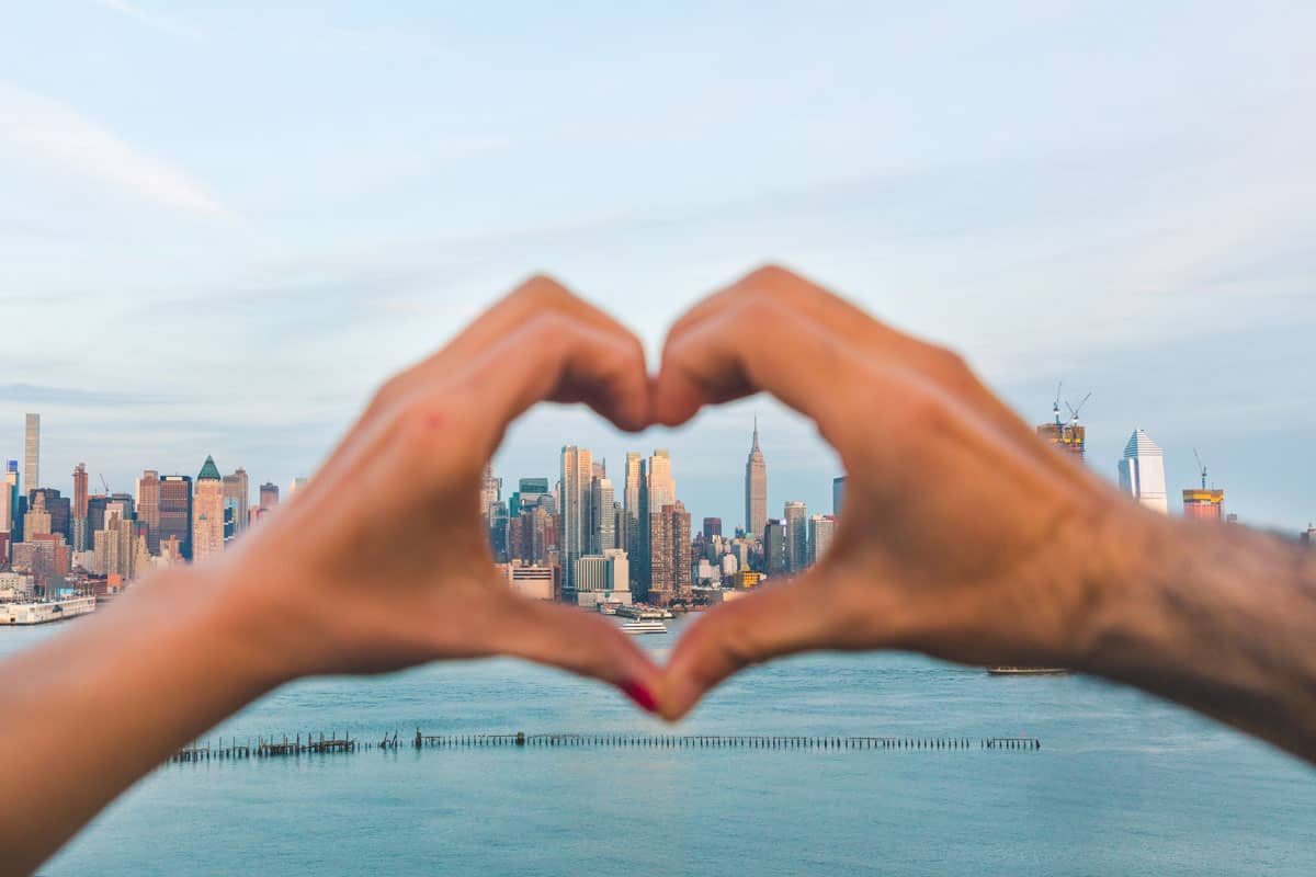 A couple making a love sign with their hands, Love in the Big Apple: The Best Last Minute Valentine's Day Activities in NYC
