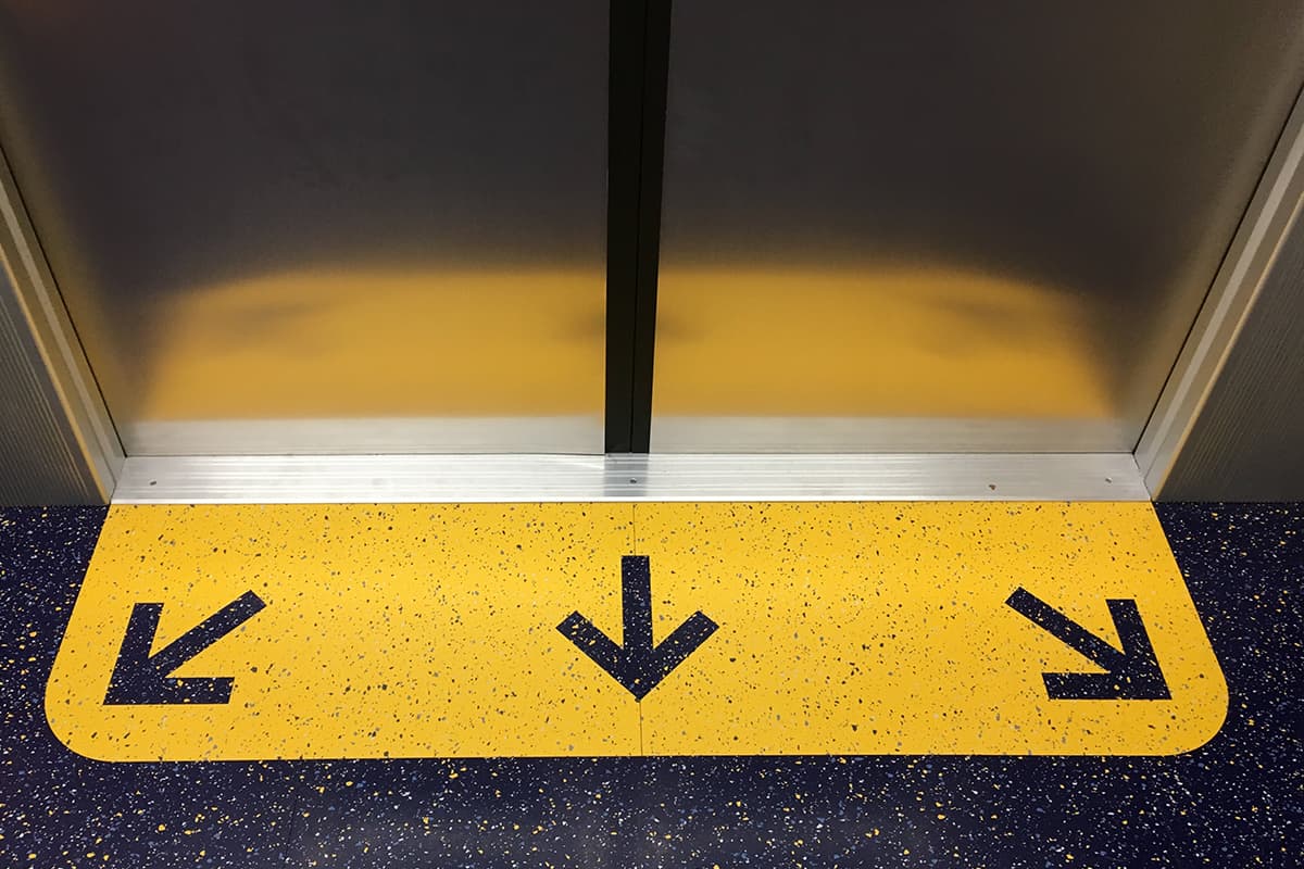 Arrows pointing in three directions in the floor graphics of an R211 subway car prototype on view in New York City