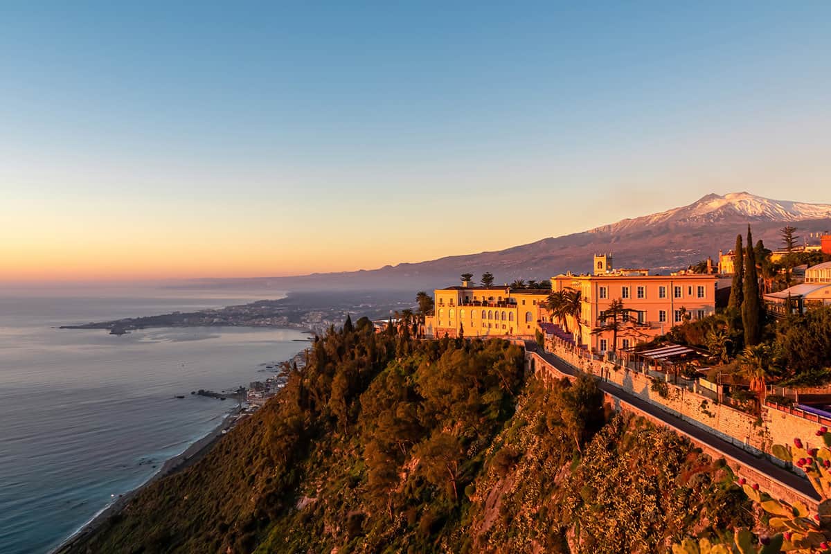 Luxury San Domenico Palace Hotel with panoramic view on snow capped Mount Etna volcano at sunrise