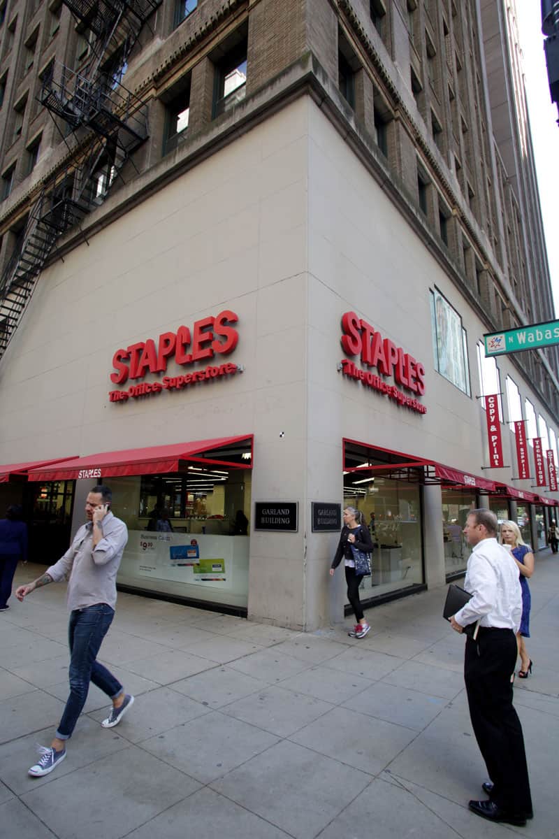 Pedestrians walk past a Staples, Inc. office supply chain store in Chicago