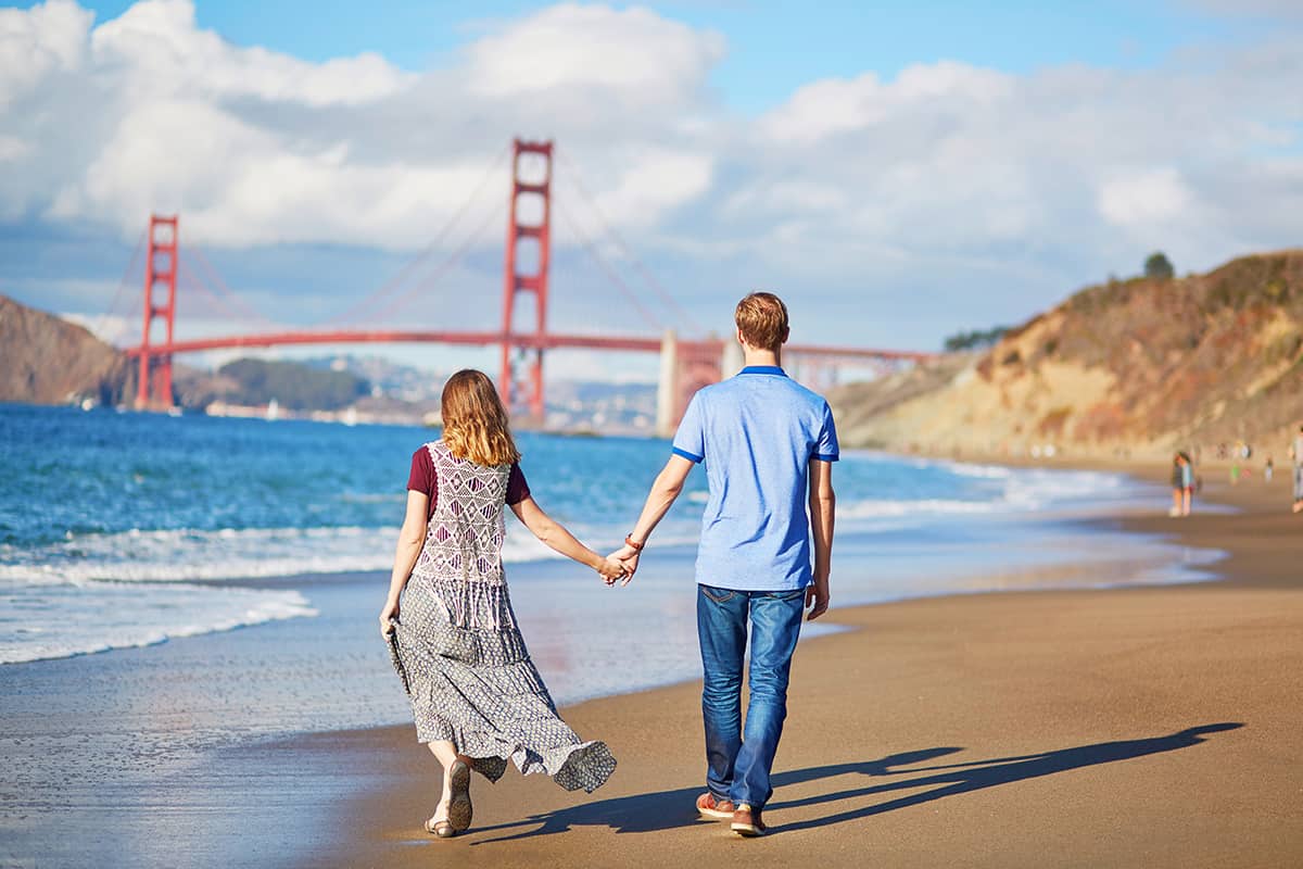 Romantic loving couple having a date on Baker beach in San Francisco, California