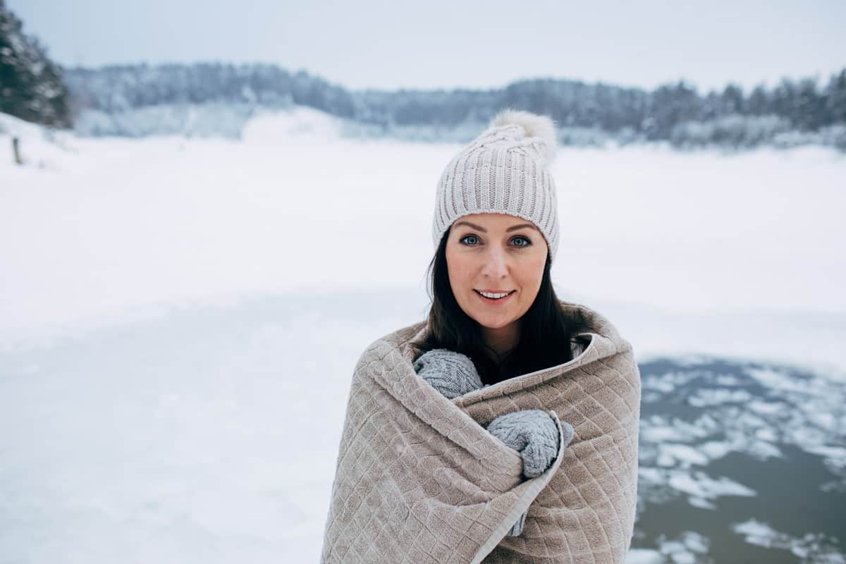 Woman in frozen lake ice hole.