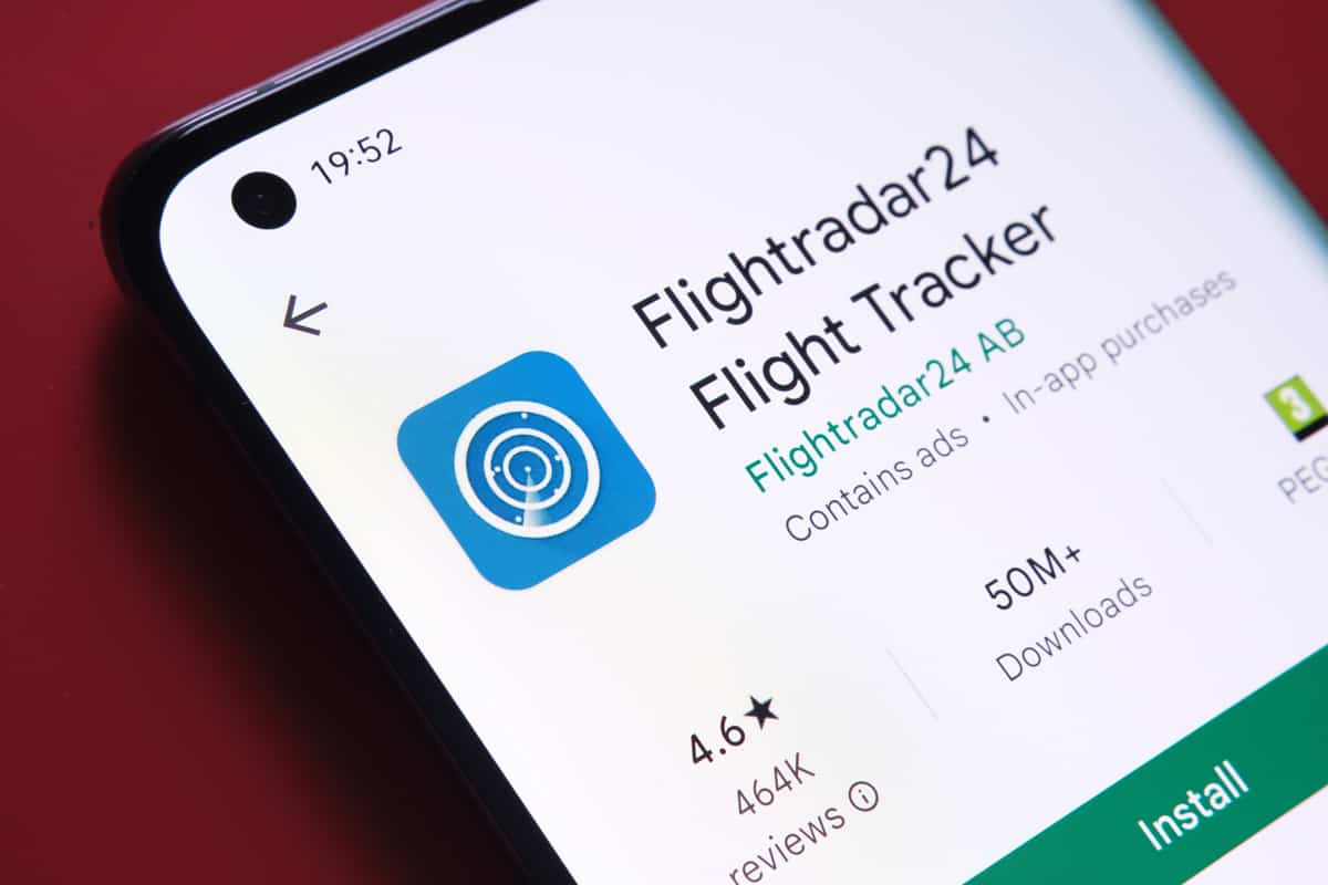 flightradar24 app seen in Google Play Store on the smartphone screen placed on red background. Close