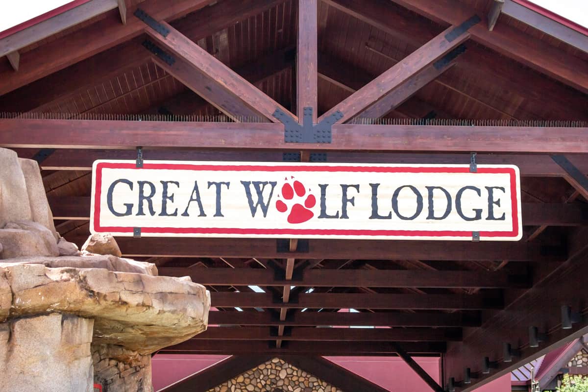 A Cabin with a hanging sign of Great Wolf Lodge