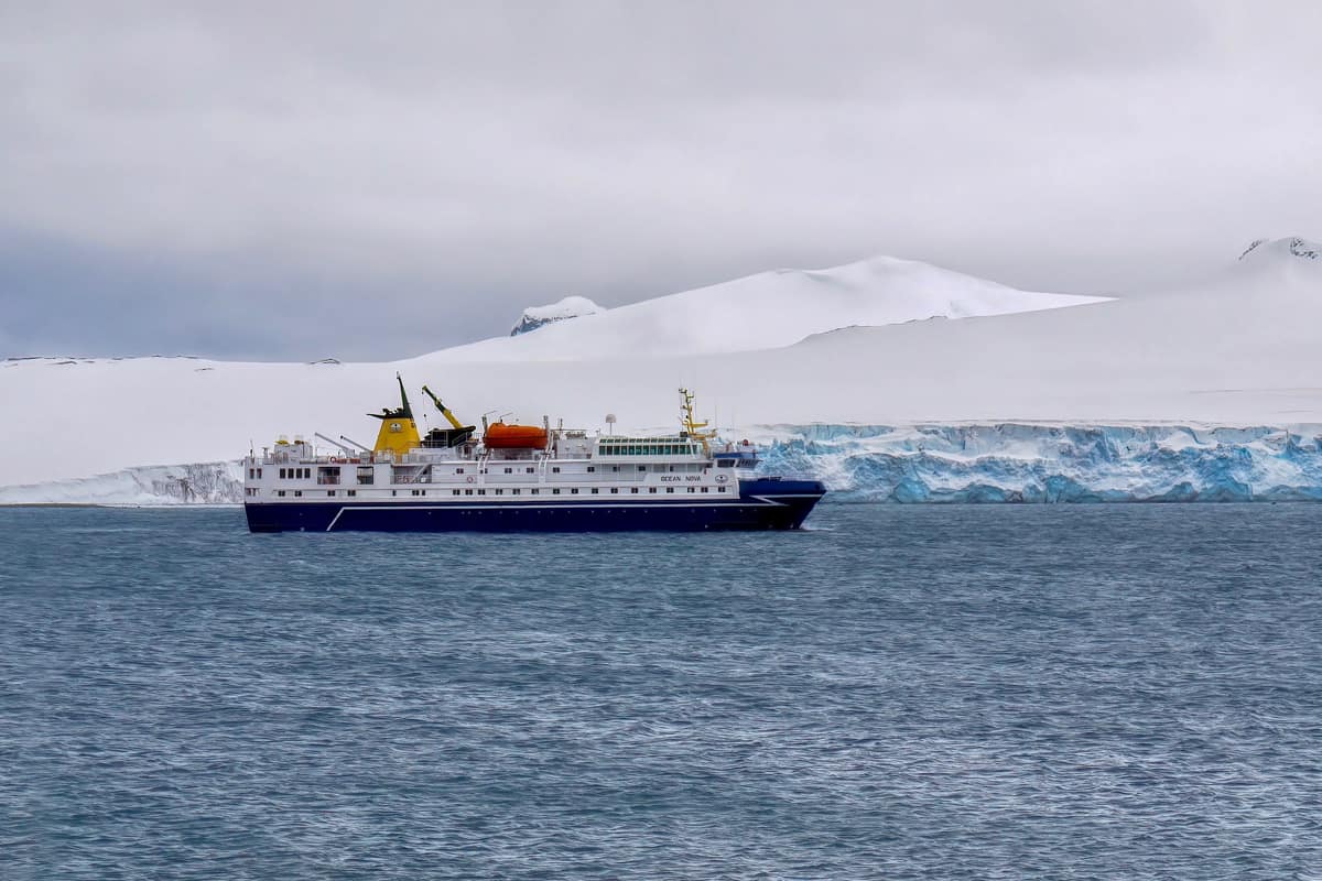 A huge ship on an Antartic expedition cruising close to the ice