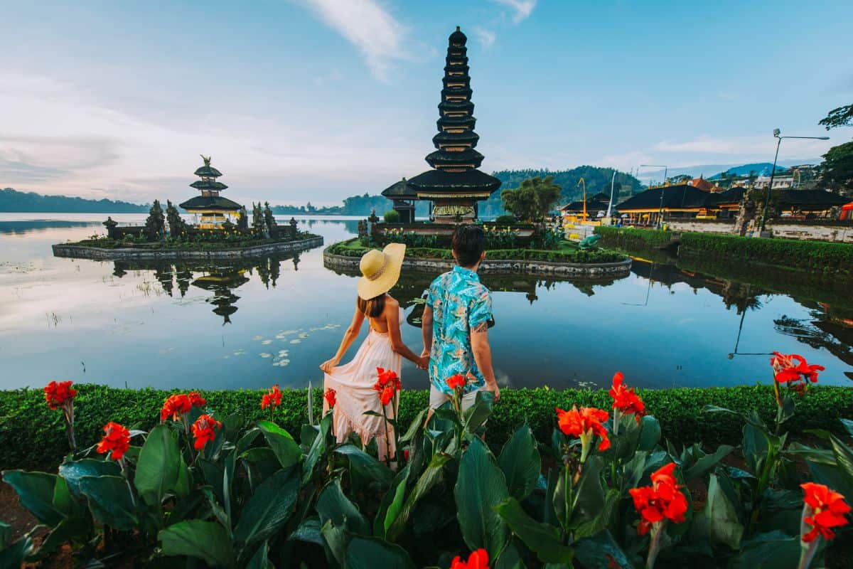 Couple spending time at the ulun datu bratan temple in Bali. Concept about exotic lifestyle wanderlust traveling.