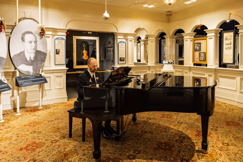 Photo of the interior of the titanic museum in branson, MO. Photo features a musician playing on a grand piano.