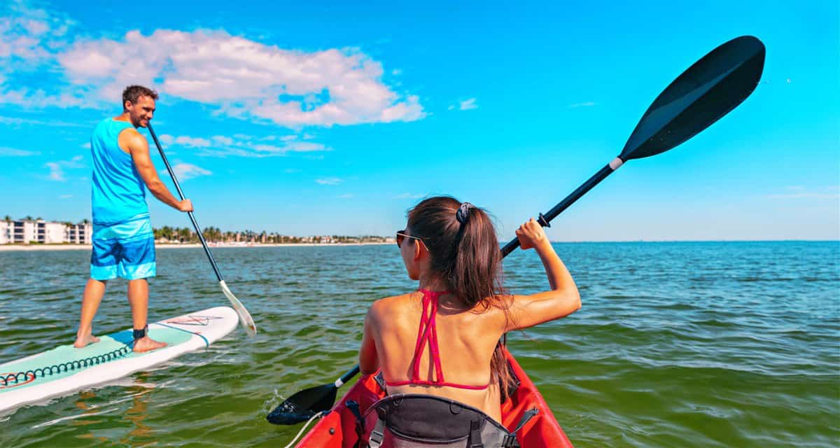 Couple kayaking and paddle boarding fitness man in ocean Paddleboard beach people on stand-up paddle boards surfing in Tourists kayakers woman and man enjoying SUP kayak waterspo