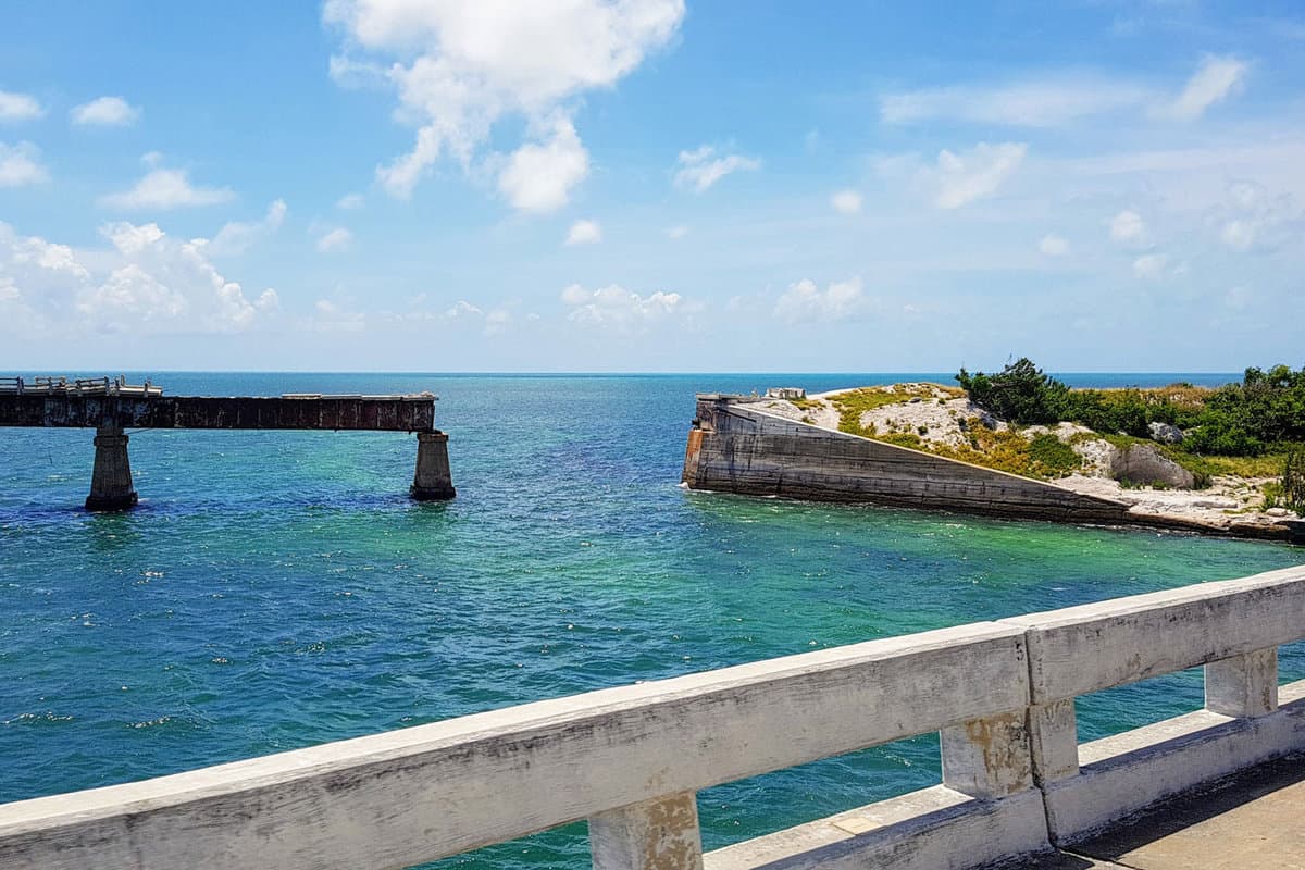 Travel by car in Florida Keys, view of Florida Overseas railway bridge over blue ocean water of Gulf of Mexico, Calusa beach and motorhomes in Bahia Honda State Park