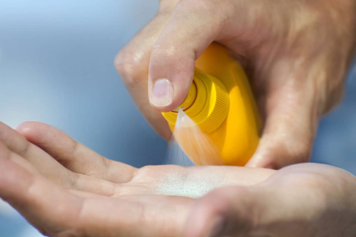 Pouring suntan lotion on hand