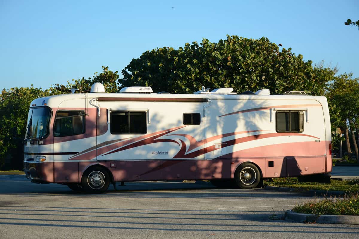 An RV bus is situated at Key West Campground, stationary and parked.