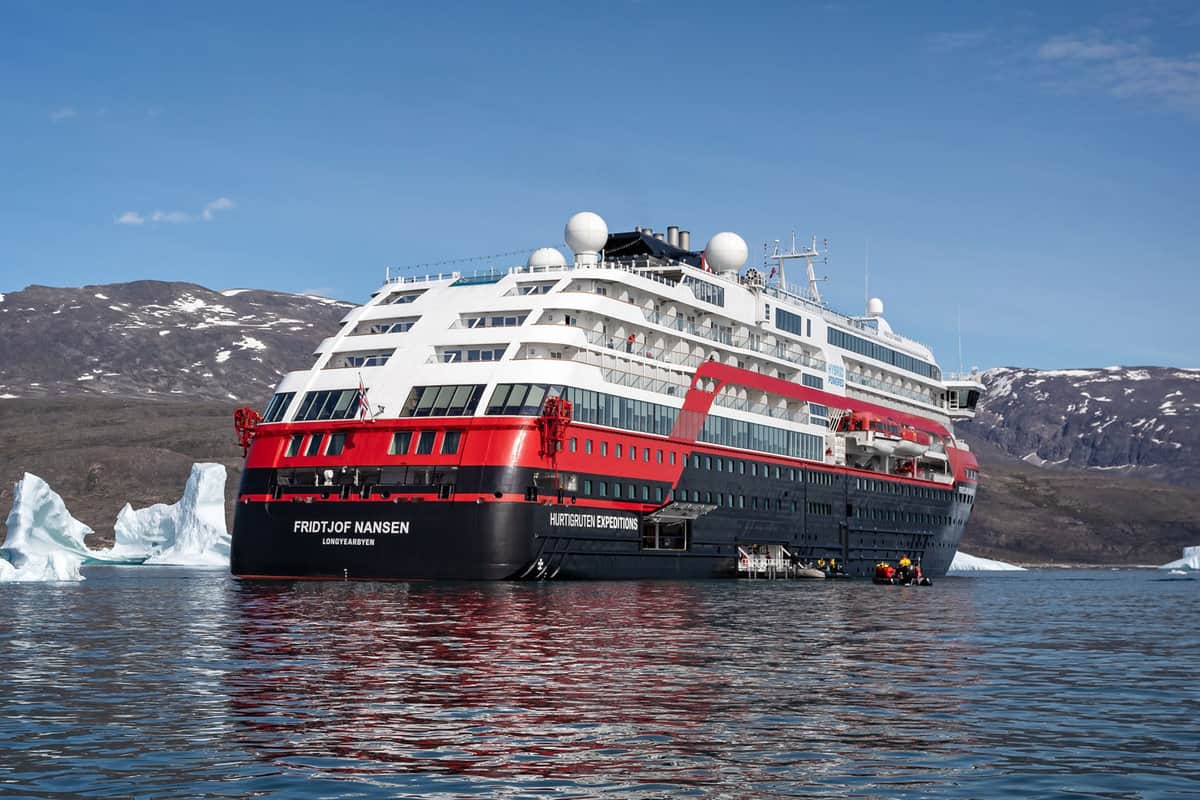 Close up of Hurtigruten's MS Fridtjof Nansen expedition cruise ship amidst icebergs with zodiacs off loading in Disko Bay