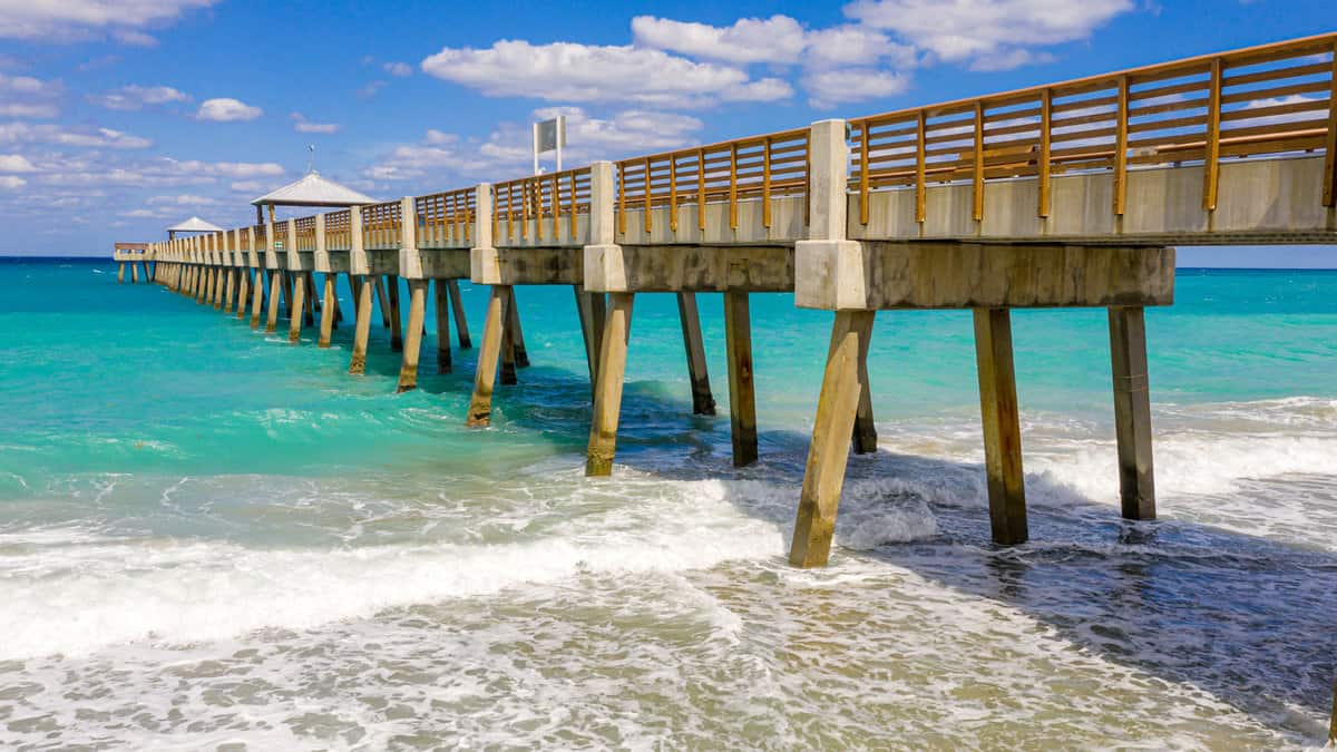 A pier at Juno Beach Pier showing the gorgeous blue waters, 13 Best Fishing Piers In Florida - 1600x900