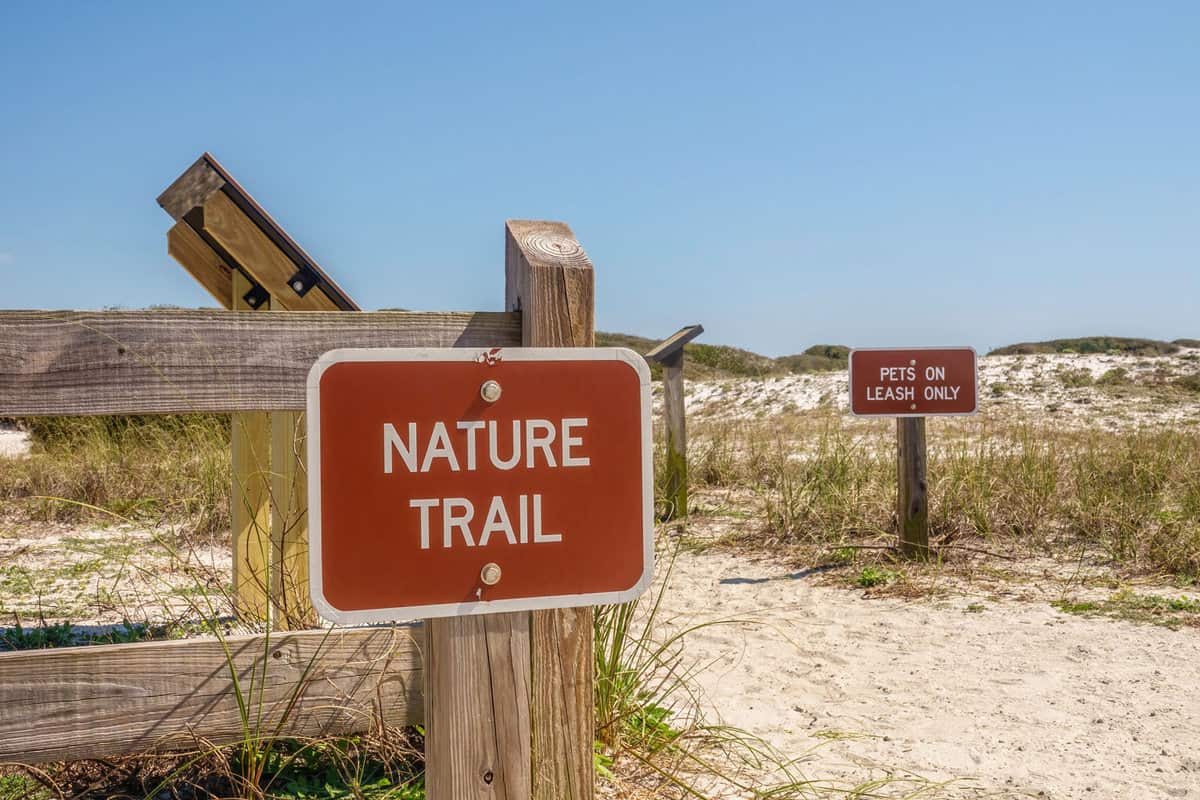 Two signs at trailhead, "Nature Trail" and "Pets on Leash Only," at Grayton Beach State Park in Santa Rosa Beach, Florida, USA