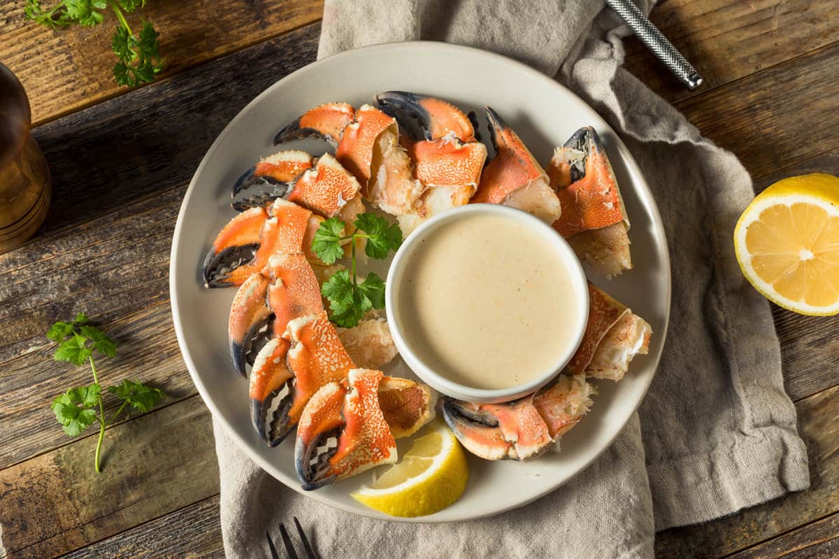 A dish filled with stone crab claw and a delicious dip
