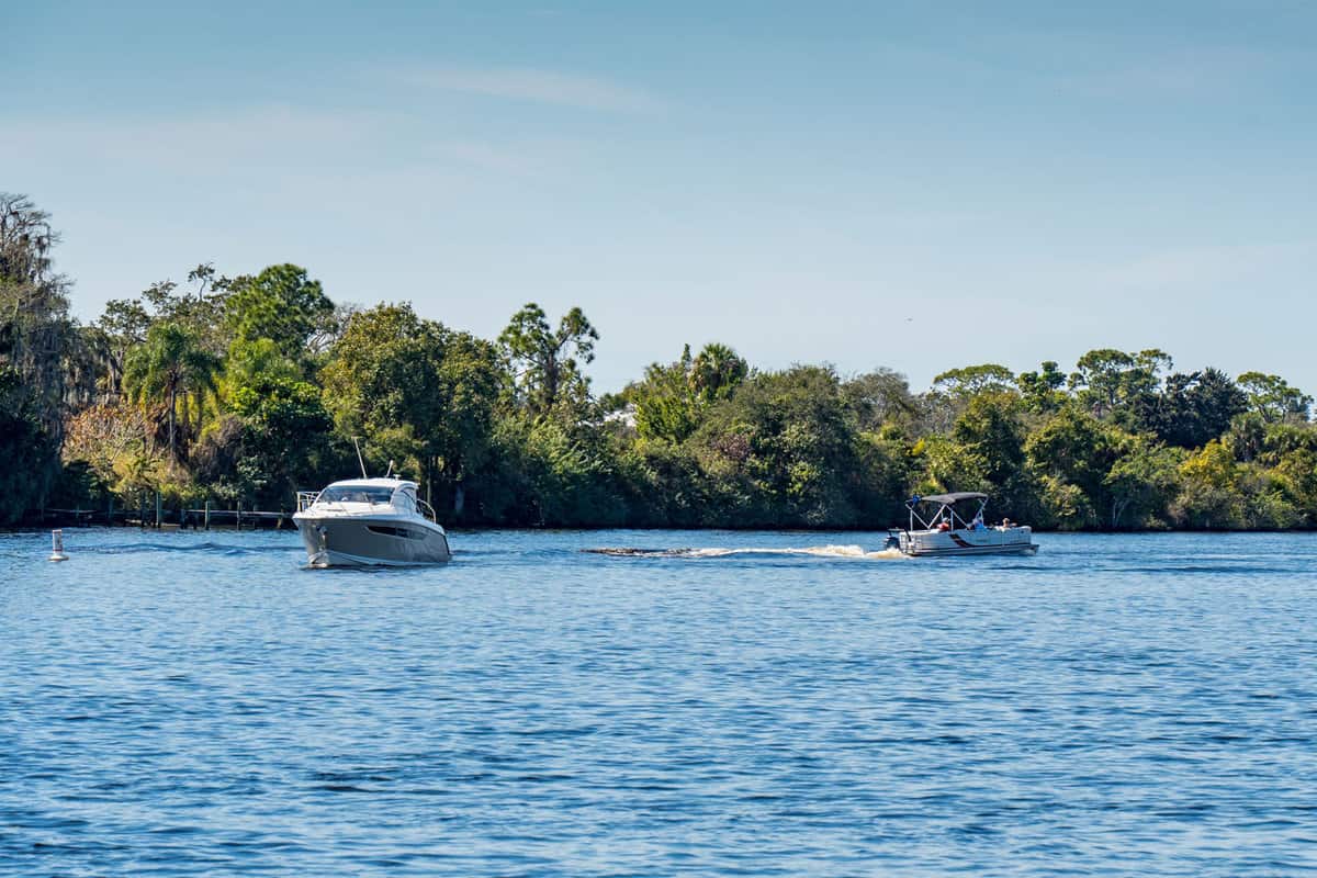 Two boats cruising along river near Franklin Locks in Lee County Florida.