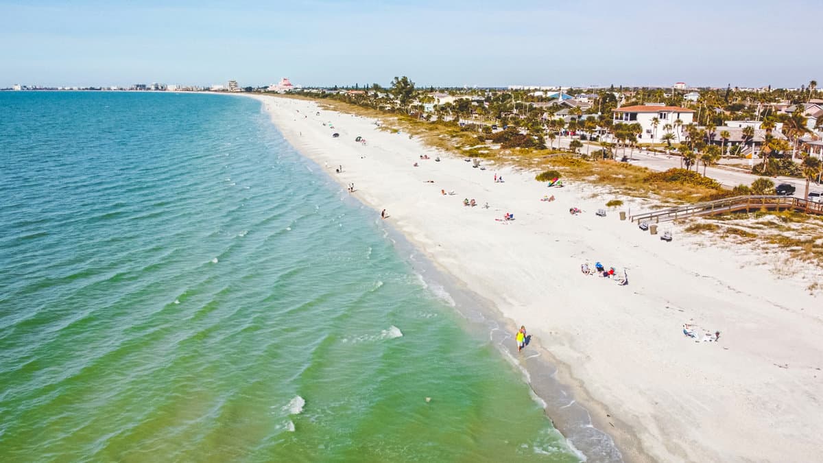 High angle view of Pass-A-Grille beach surrounded by turquoise waters against sky as beach goers enjoy the winter Florida sun.