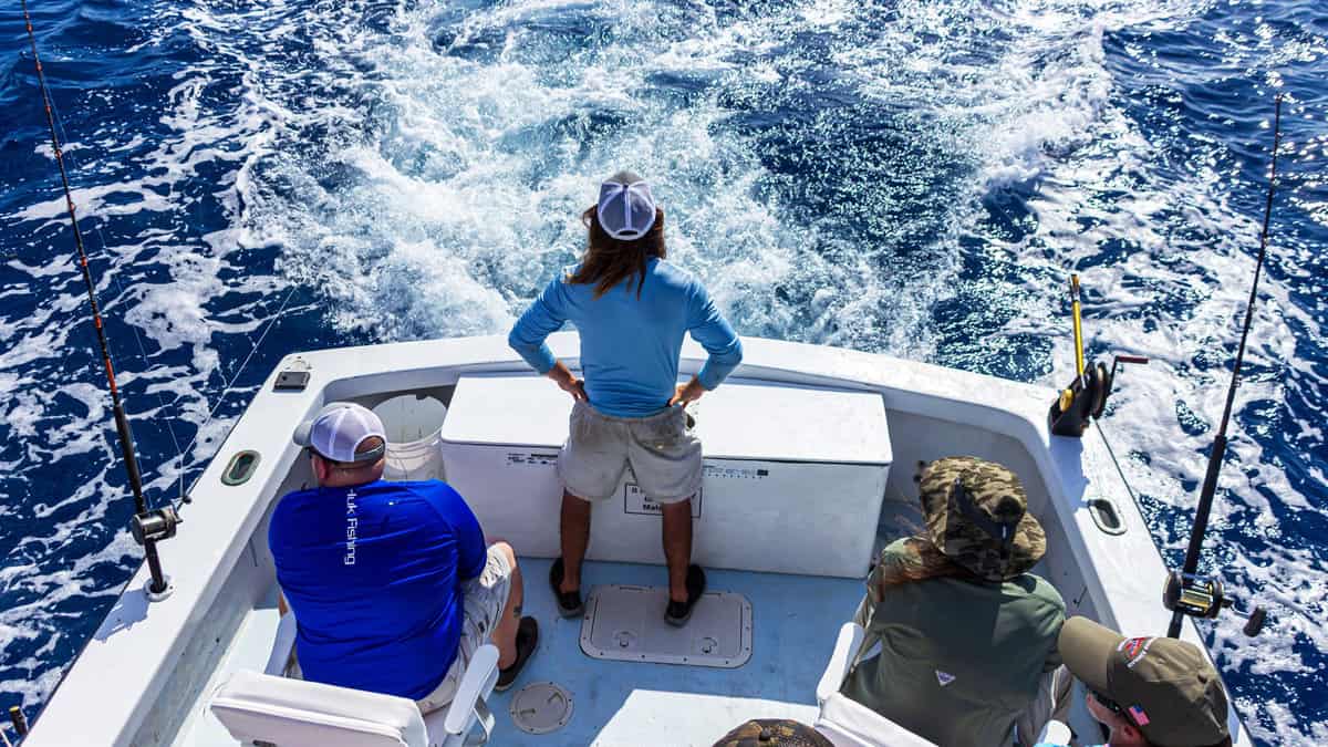 Keaton Cook, First Mate on the charter fishing boat "Reef Runner," checks the rigging on the boat while trolling for sailfish 
