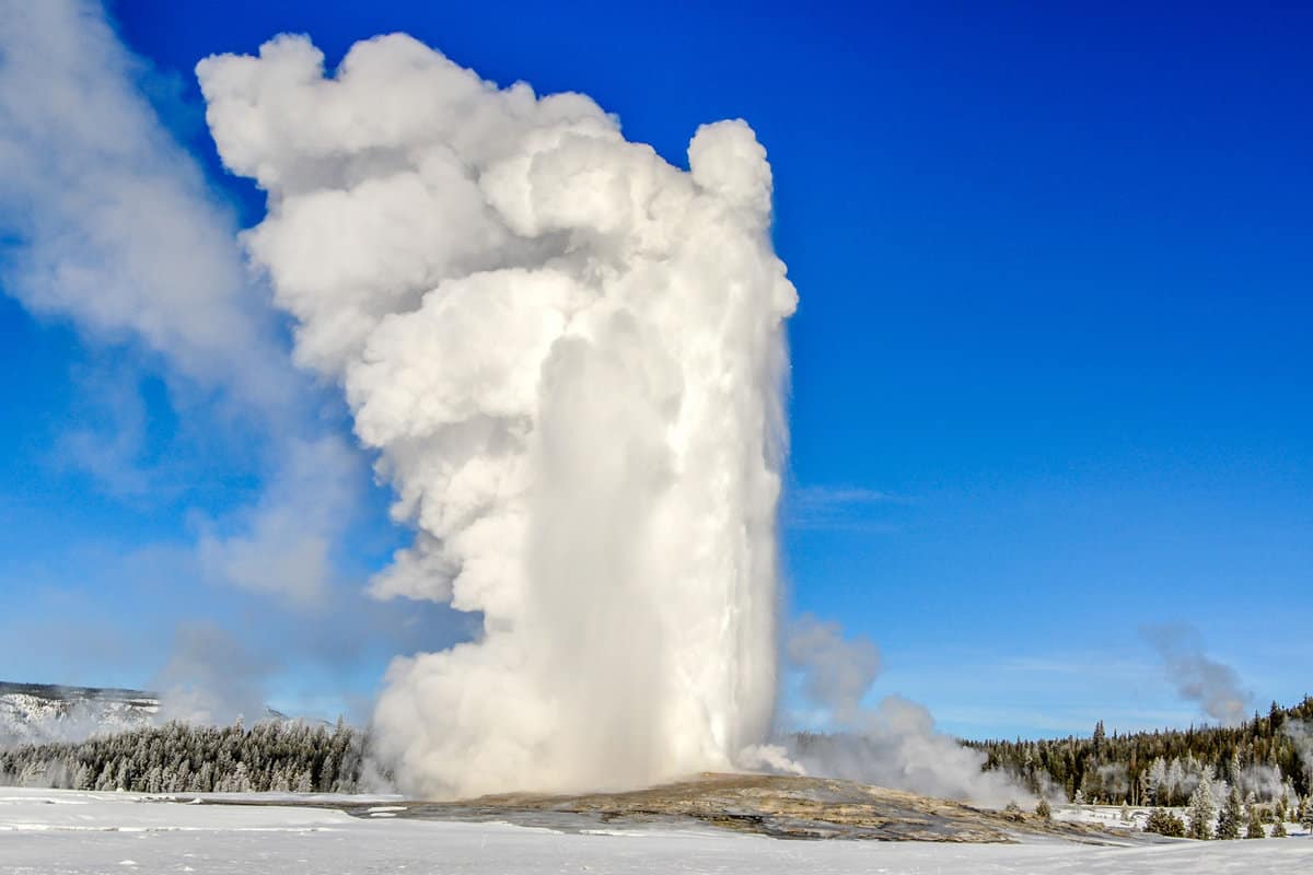 A huge stream of hot water and steam emitting from Old faithful geyser