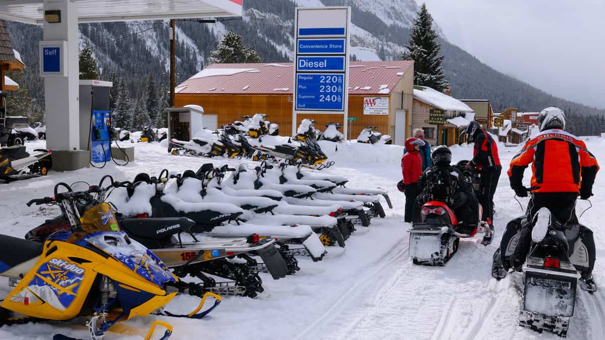 Snowmobiles in Cooke City Montana at a gas station in winter