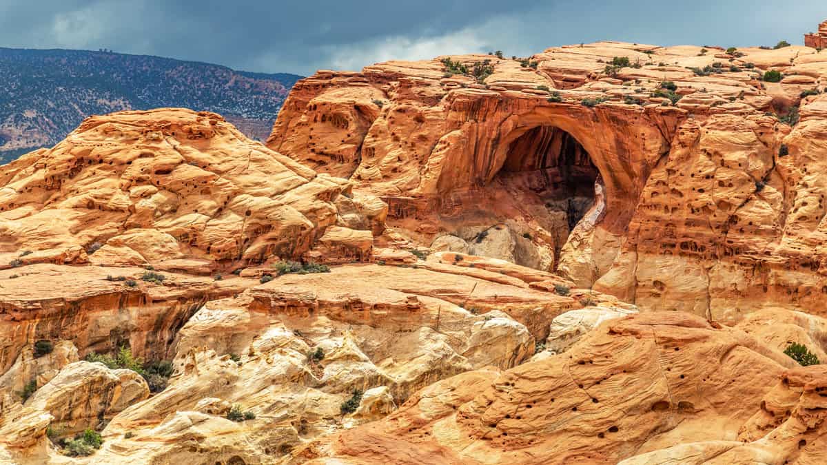Hiking to Cassidy Arch with stormy skies in Capitol Reef National Park, Utah