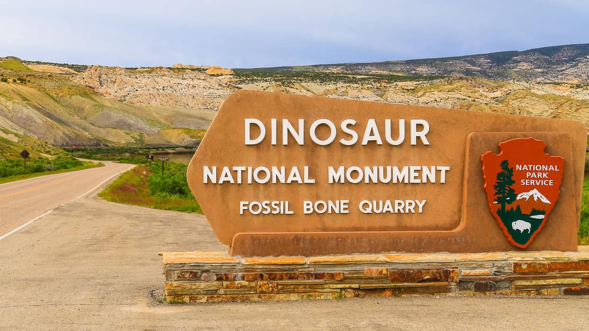 Entrance sign of the Dinosaur National Monument and the quarry that contains dinosaur fossils.