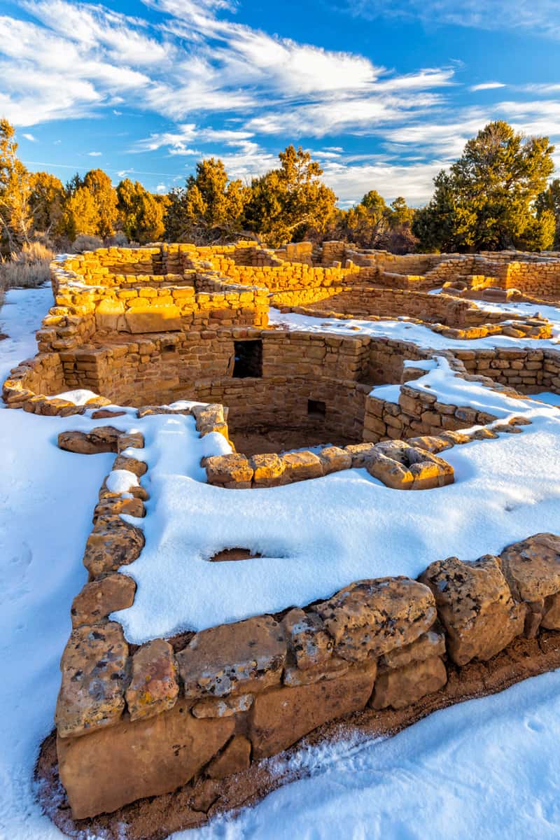 Snow surrounds the remains of mesa top Coyote Village on Chapin Mesa in Mesa Verde National Park, Colorado