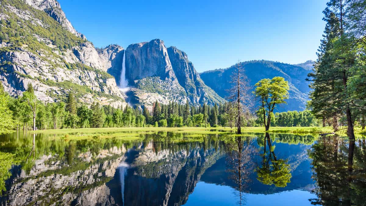 Yosemite National Park - Reflection in Merced River of Yosemite waterfalls and beautiful mountain landscape, hiking in the beautiful nature of California, USA