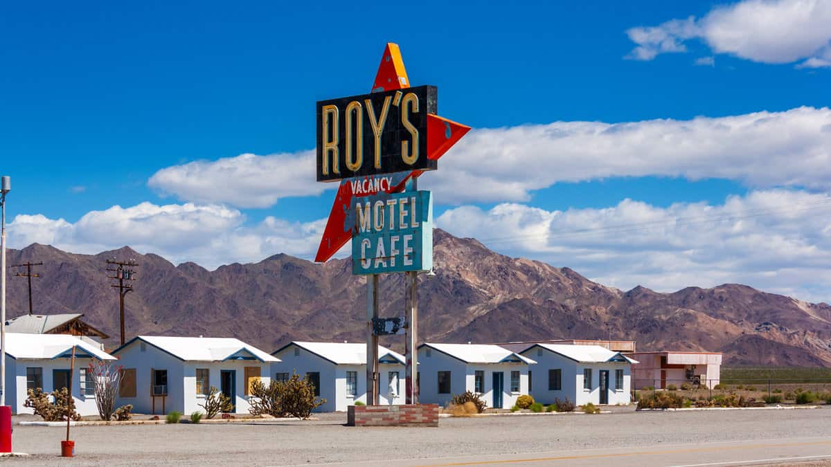 View of the historical Roy’s Motel sign and small cabins located on Route 66 in Amboy, California