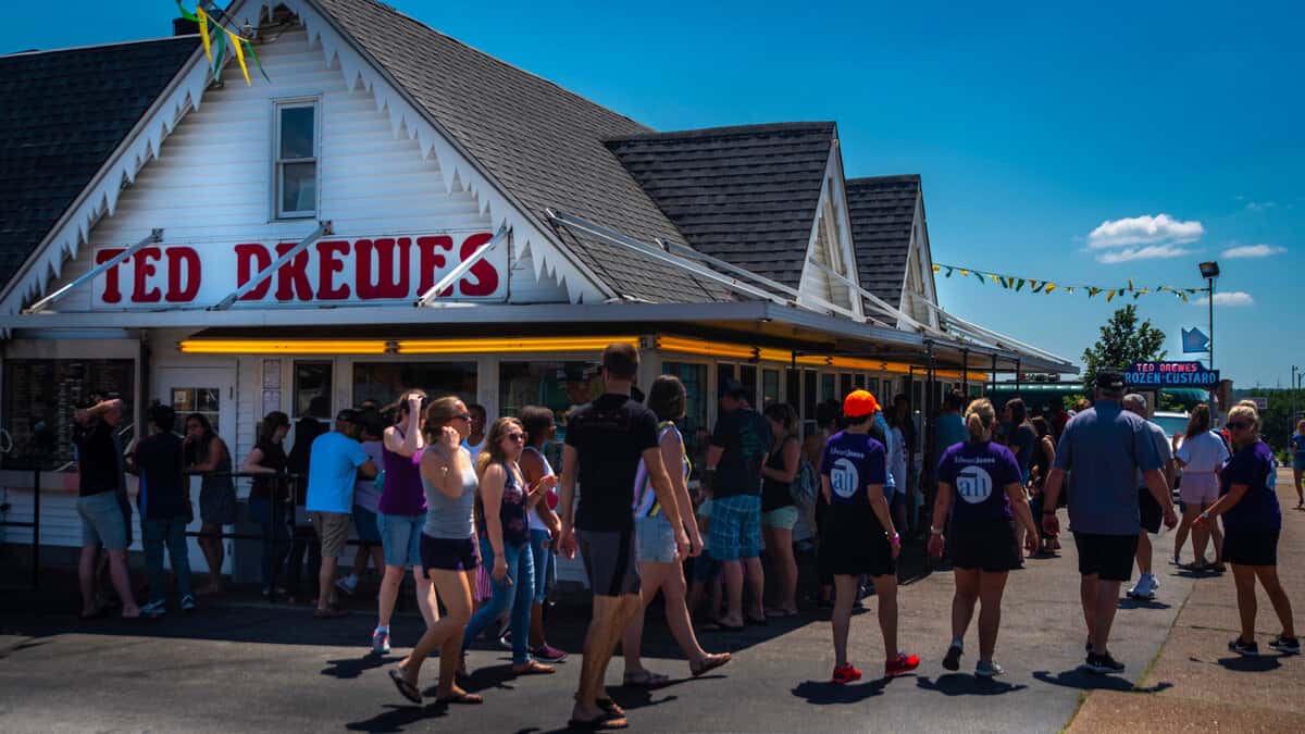 patrons standing outside in lines at service windows at Ted Drews frozen custard and ice cream shop on Route 66 in St. Louis Missouri during summer