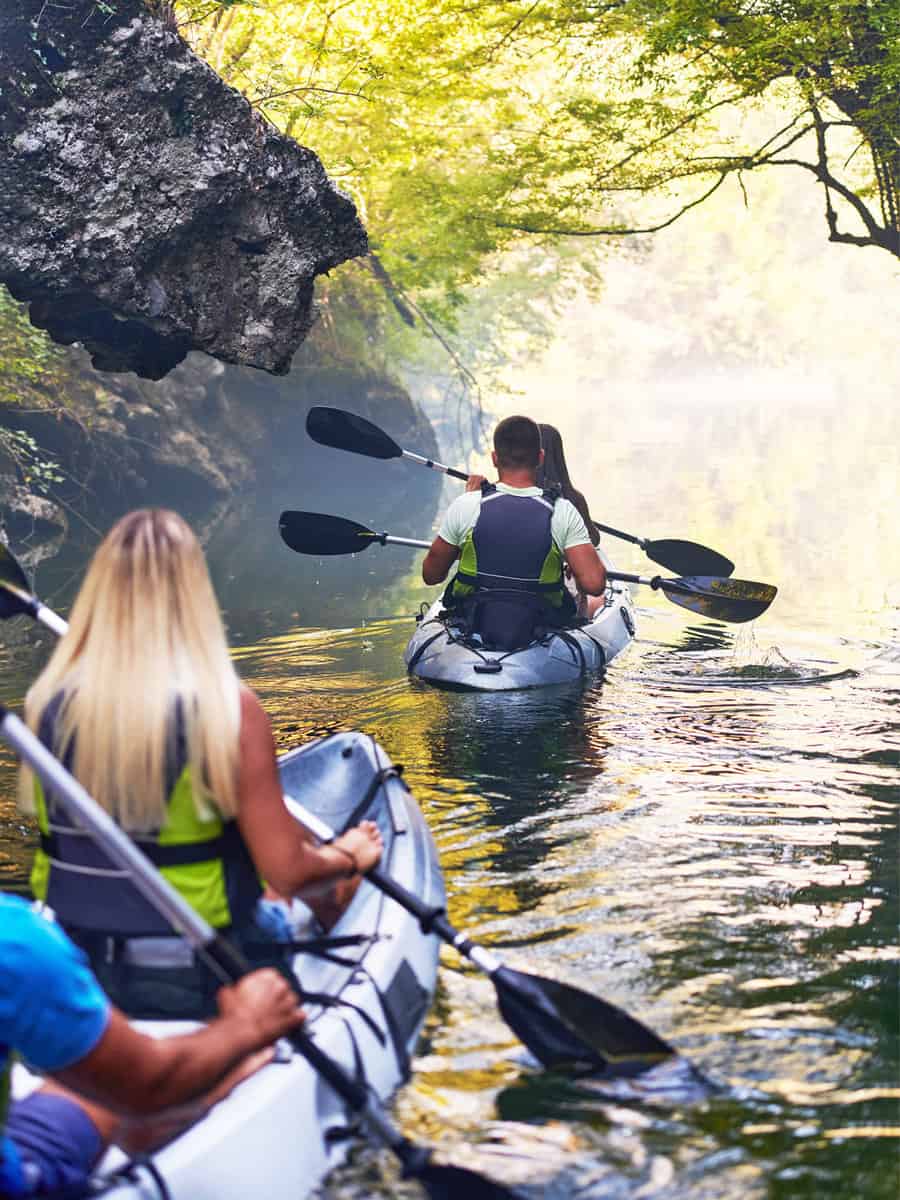 A group of friends enjoying having fun and kayaking while exploring the calm river