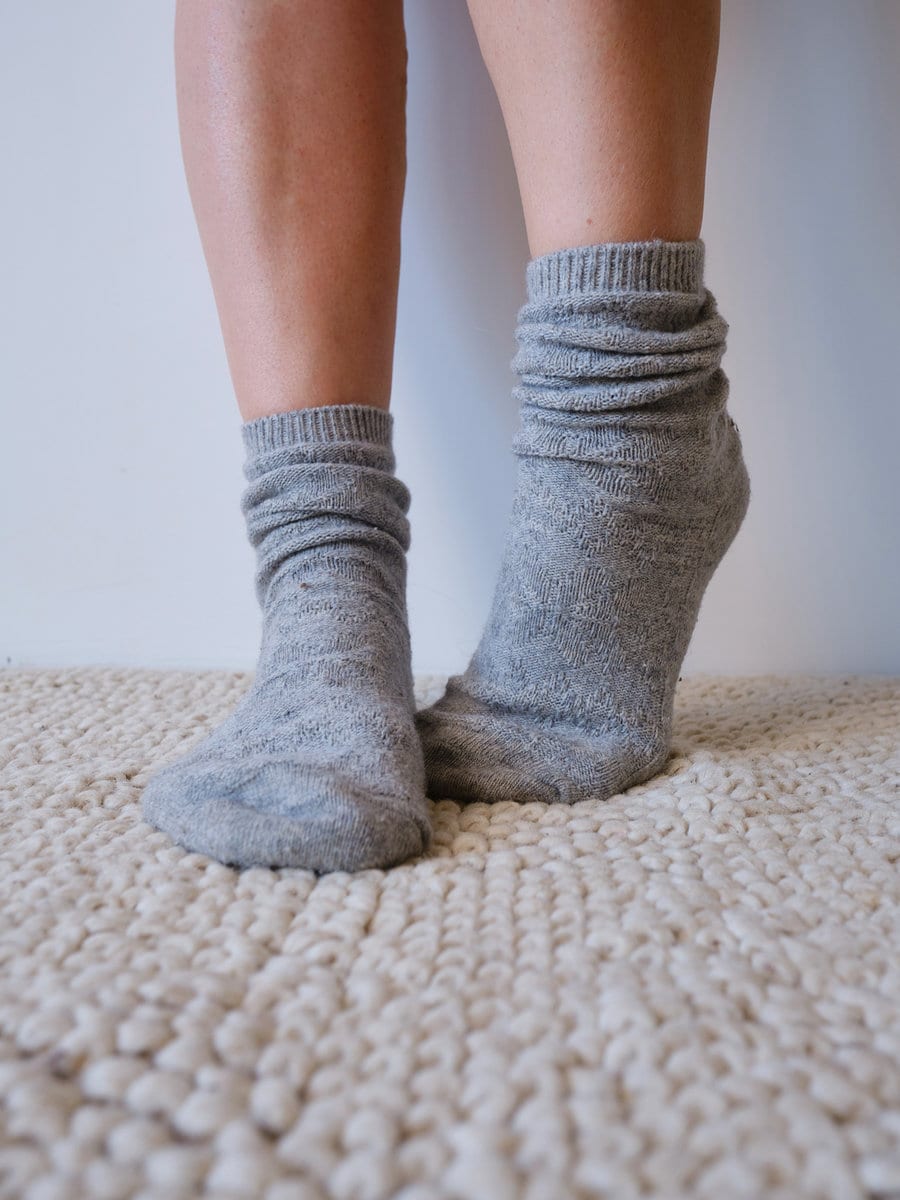 Beautiful female legs in cozy knitted socks close-up. Warm socks for cold weather