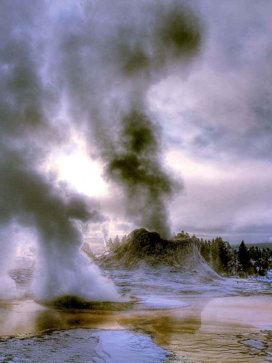 CASTLE GEYSER ERUPTS IN THE WINTER AT YELLOWSTONE NATIONAL PARK,WYOMING