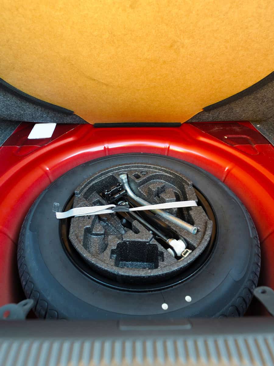 Spare tire in the trunk of a red modern car
