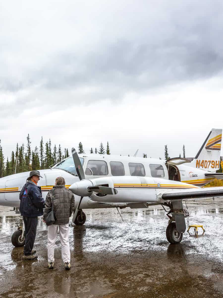 Tourists getting on board in a small private shuttle plane to Fairbanks in a cloudy rainy day in Coldfoot, Alaska