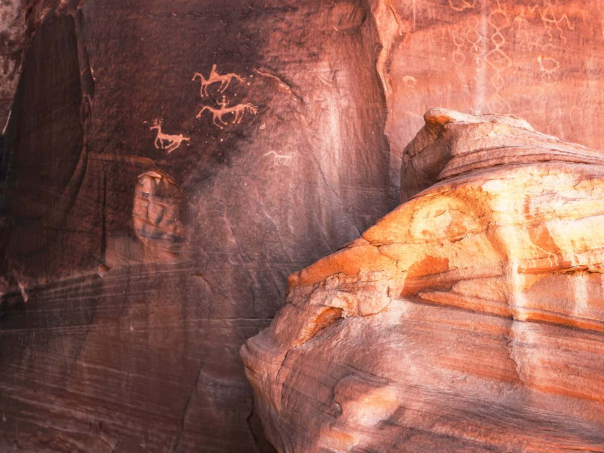 Carved Anasazi petroglyphs representing two horse riders hunting an animal related to deer - Canyon de Chelly National Monument - Arizona.