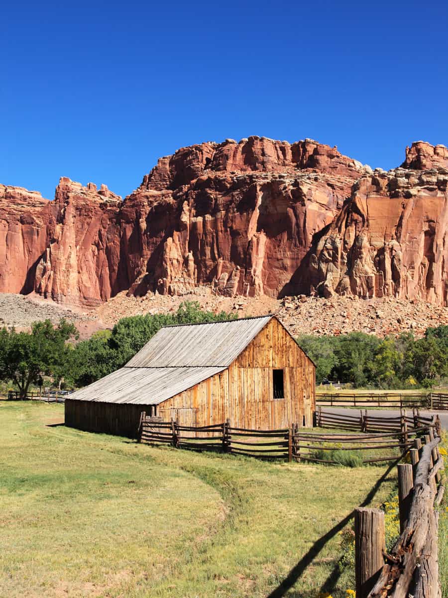 Scenic view of Historic Gifford Barn with red rocks at Fruita area in Capitol Reef National Park in Utah, USA