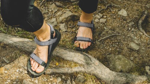 Traveler Feet in tourist sandals hiking in mountains Travel Lifestyle adventure active summer vacations outdoor concept 1600x900